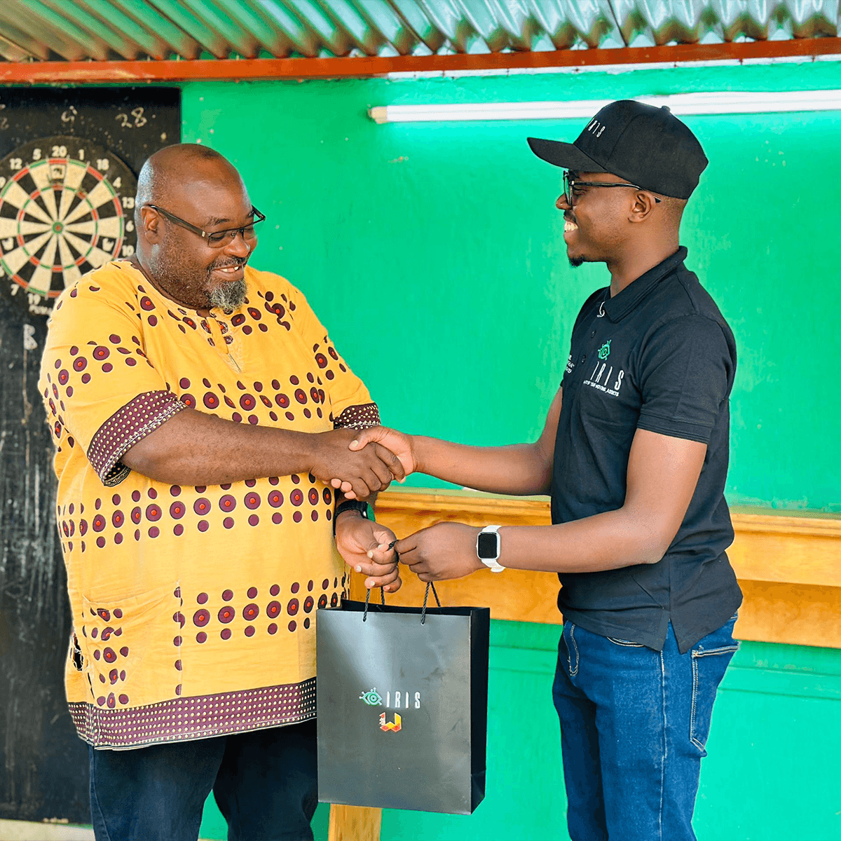 An iRis team member handing over a tracker to a happy client